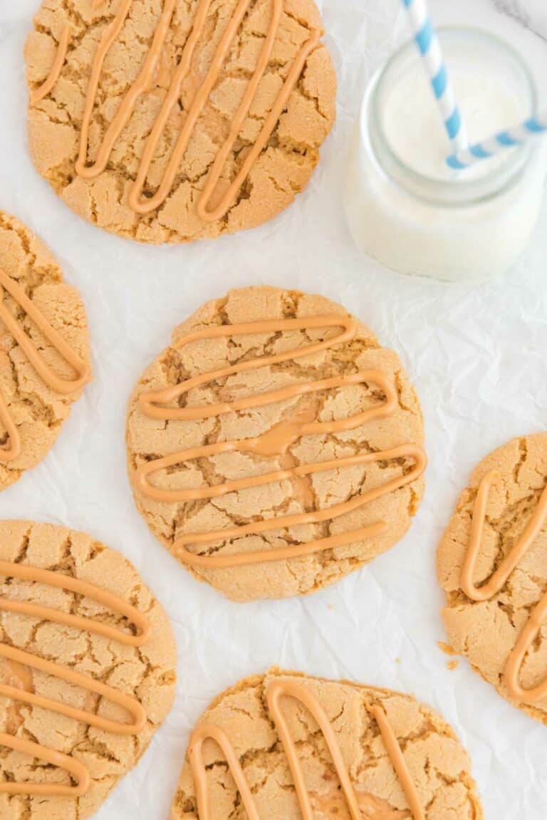 Overhead view of copycat Crumbl ultimate peanut butter cookies and a glass of milk.