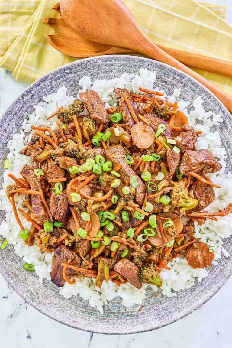 Overhead view of teriyaki beef stir fry over rice on a plate.