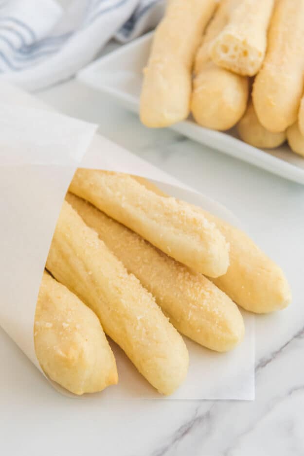 Copycat Little Caesars crazy bread wrapped in parchment and on a platter.