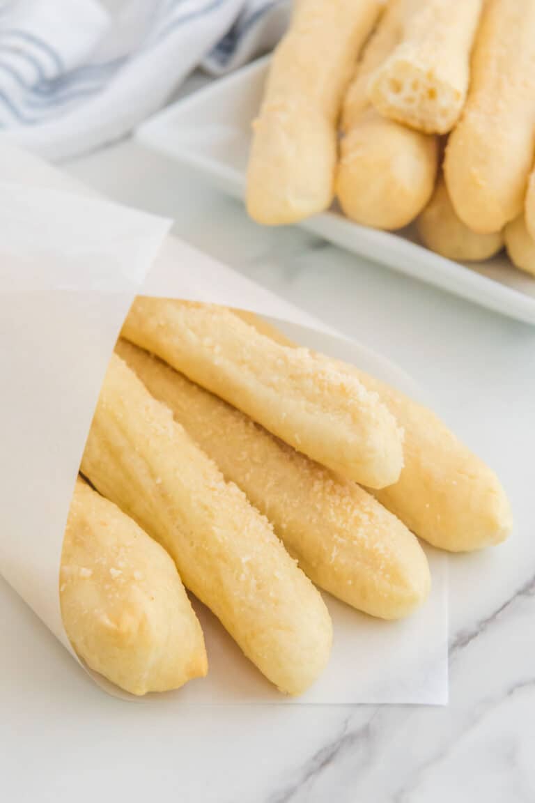 Copycat Little Caesars crazy bread wrapped in parchment and on a platter.