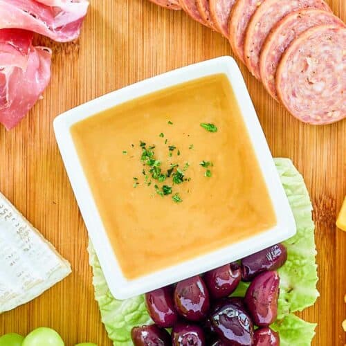 Overhead view of homemade sweet hot mustard on a charcuterie board.