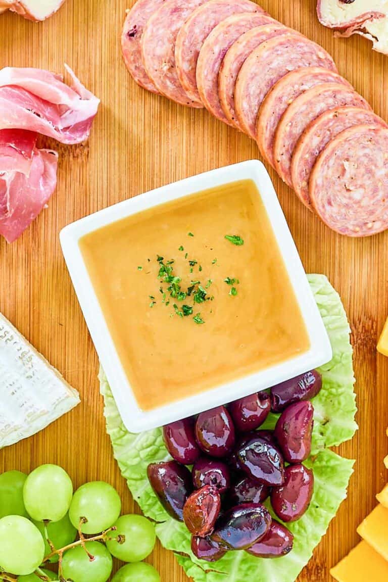 Overhead view of homemade sweet hot mustard on a charcuterie board.