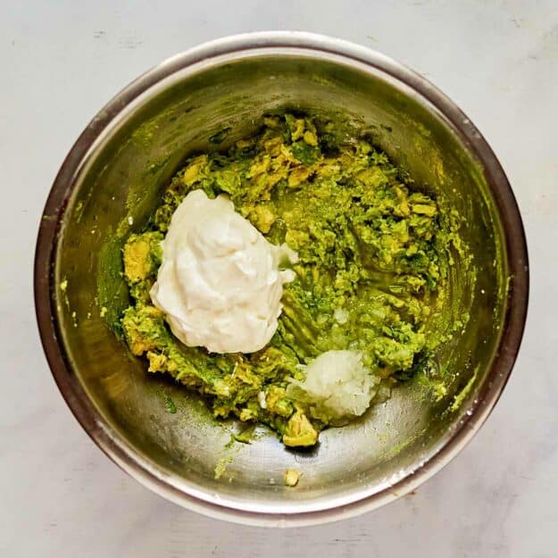 Avocado dip ingredients in a mixing bowl.