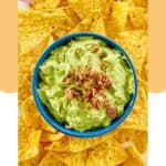 Overhead view of creamy avocado dip and tortilla chips on a platter.