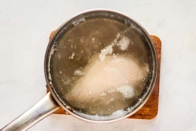 Boiling chicken breast in a pan.