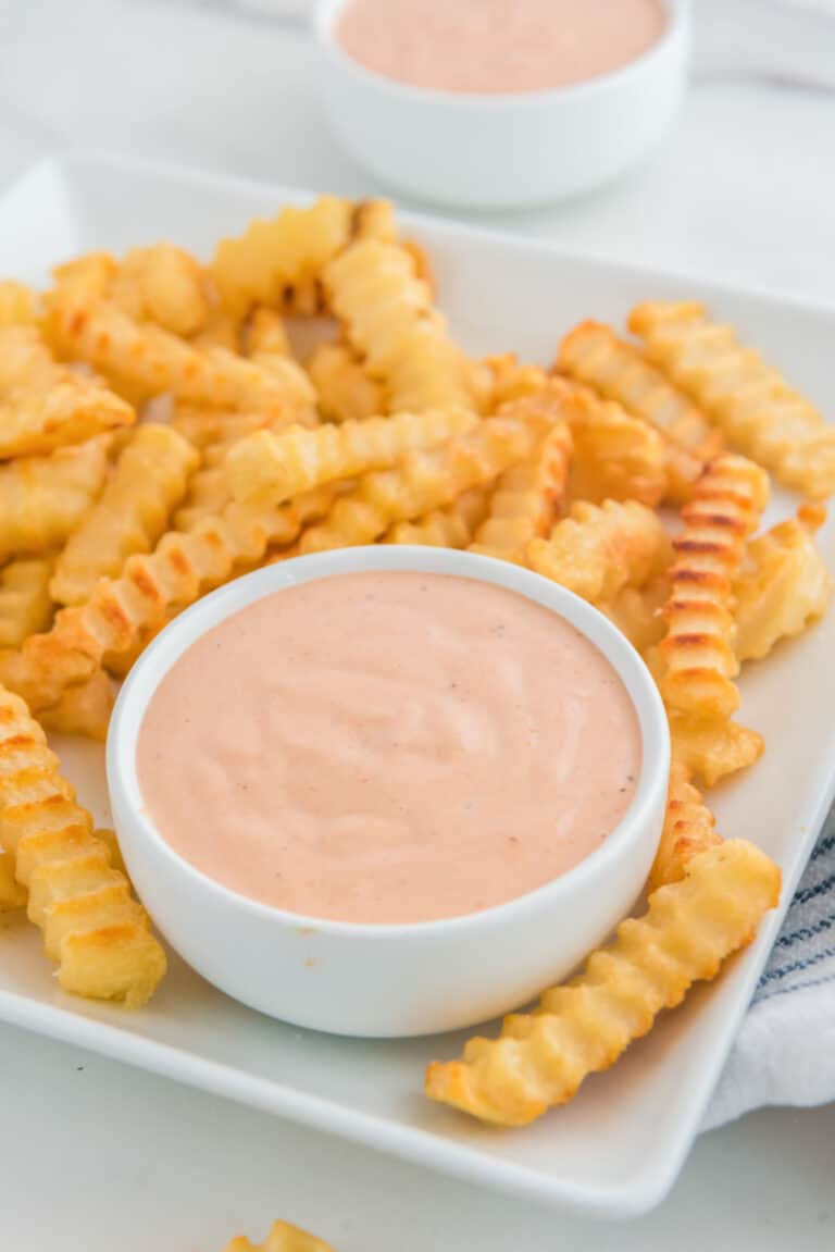Copycat Raising Cane's sauce and crinkle-cut French fries on a plate.
