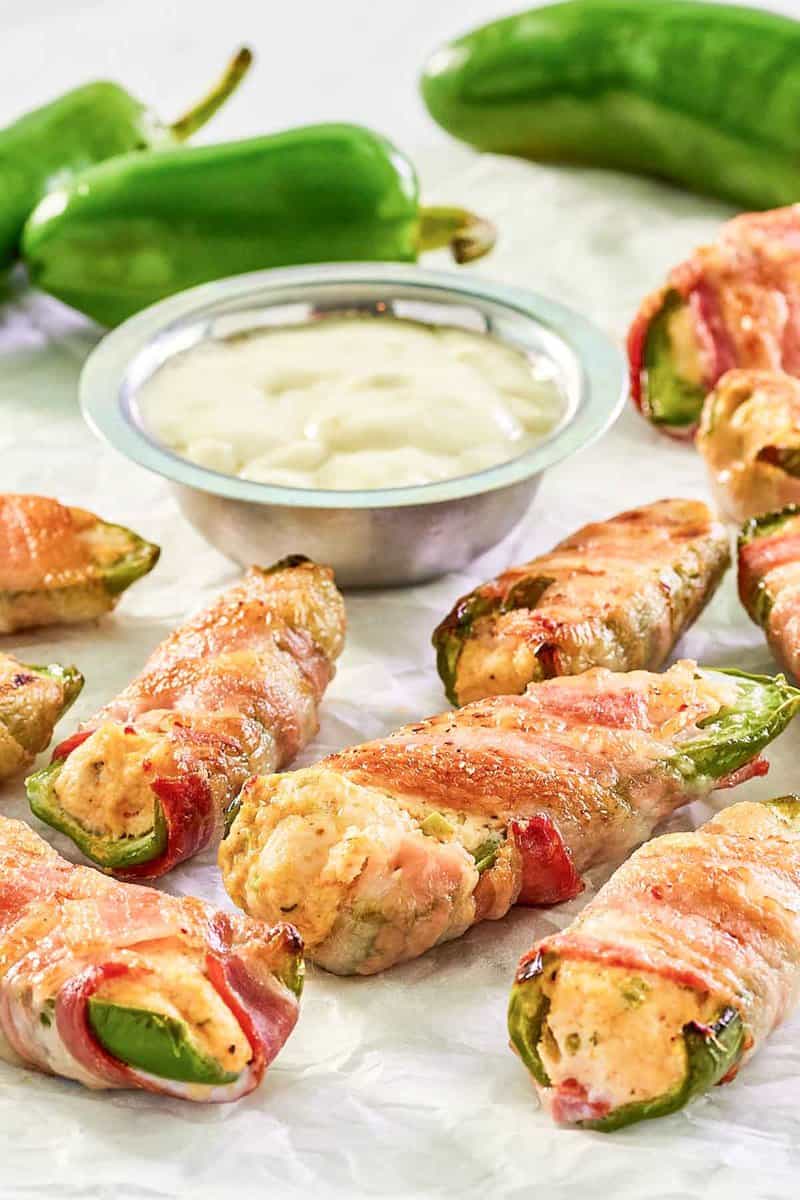 Bacon wrapped buffalo chicken jalapeno poppers, dipping sauce, and jalapeno peppers.