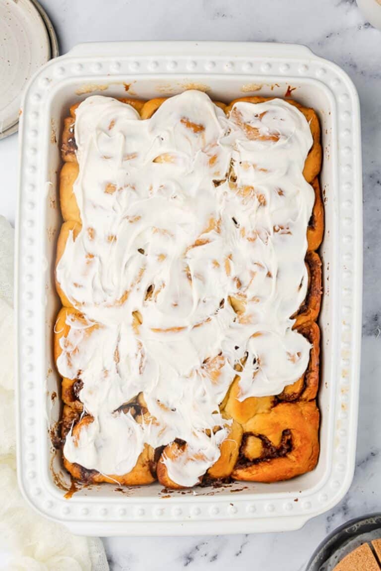 Overhead view of homemade overnight cinnamon rolls in a white baking dish.