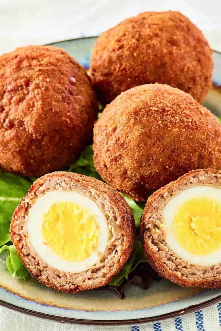 Scotch eggs on a plate.