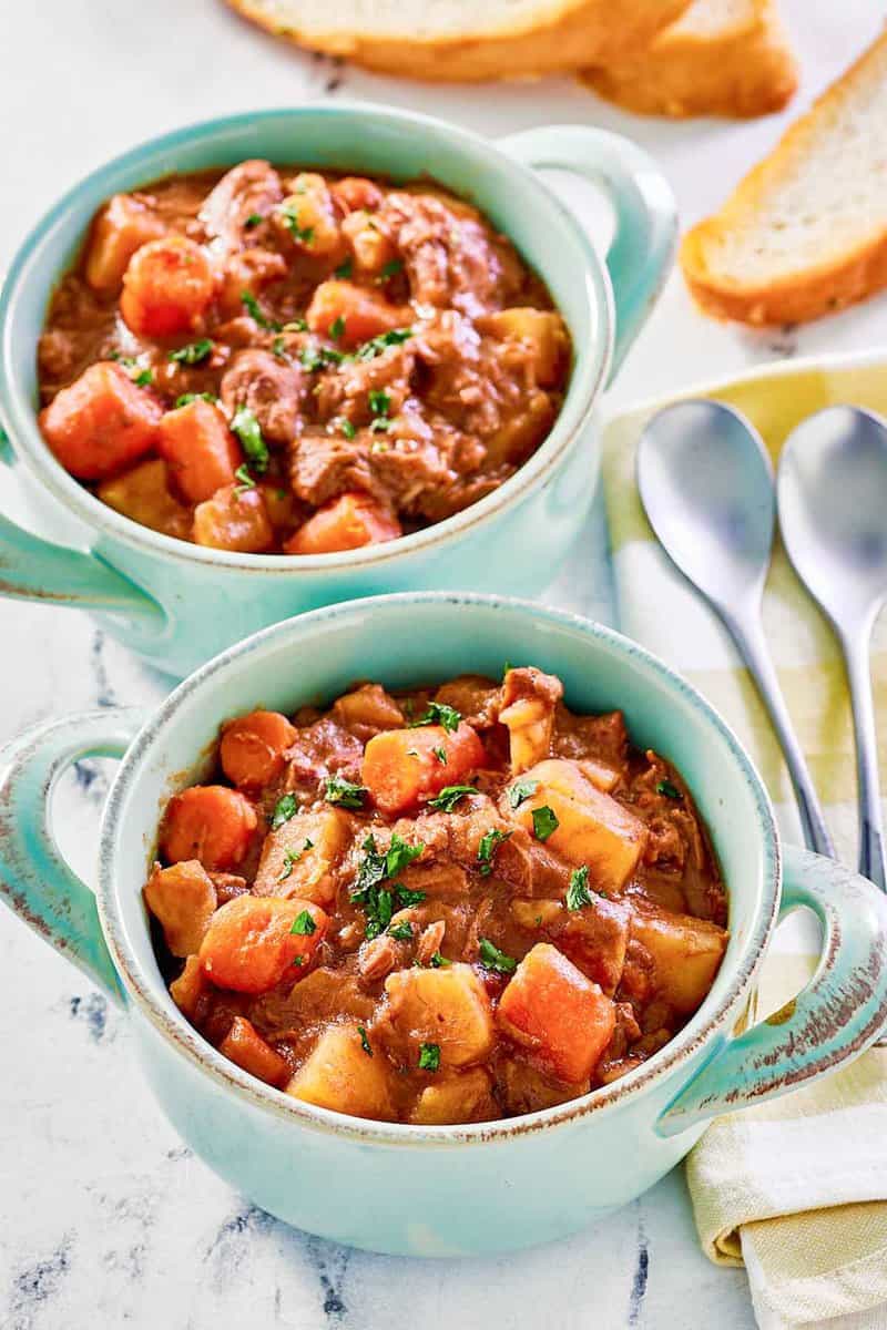 Crockpot beef stew with potatoes and carrots in two bowls.