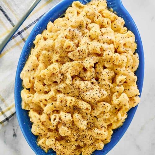 Homemade mac and cheese, a spoon, and a cloth napkin.