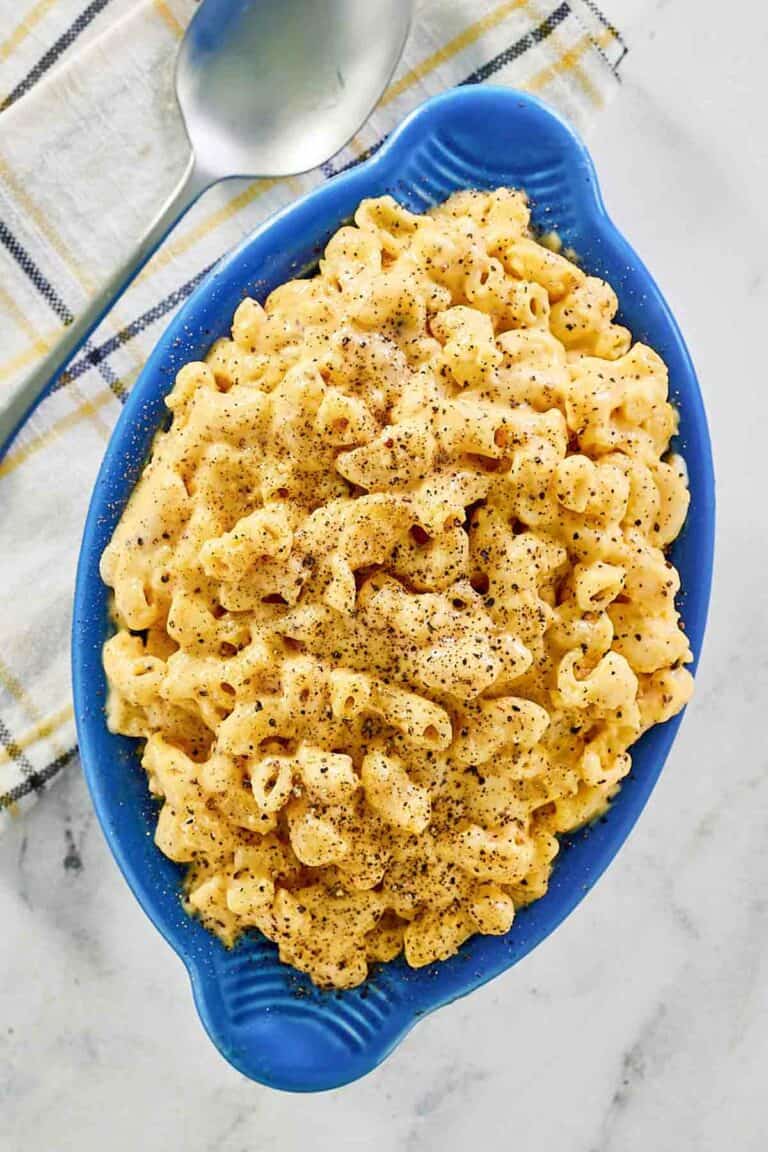 Homemade mac and cheese, a spoon, and a cloth napkin.