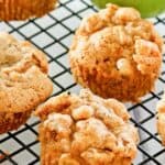Homemade apple muffins on a wire rack.