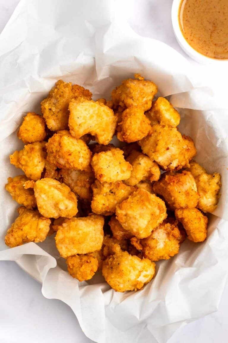 Copycat Chick Fil A chicken nuggets in a parchment paper lined basket.