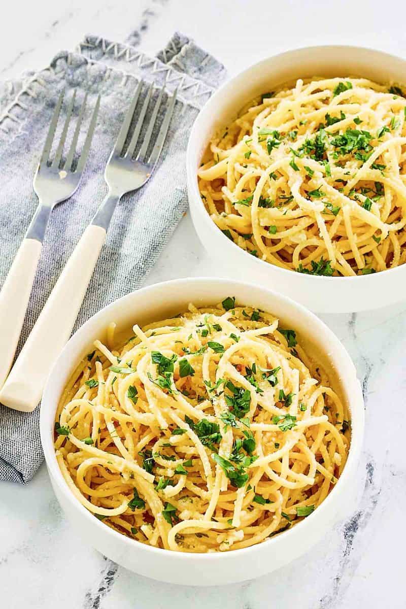 Two bowls of copycat Spaghetti Warehouse spaghetti with garlic butter.
