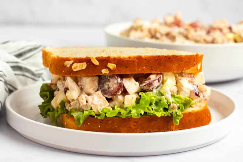 Copycat Arby's pecan chicken salad sandwich with lettuce on a plate.