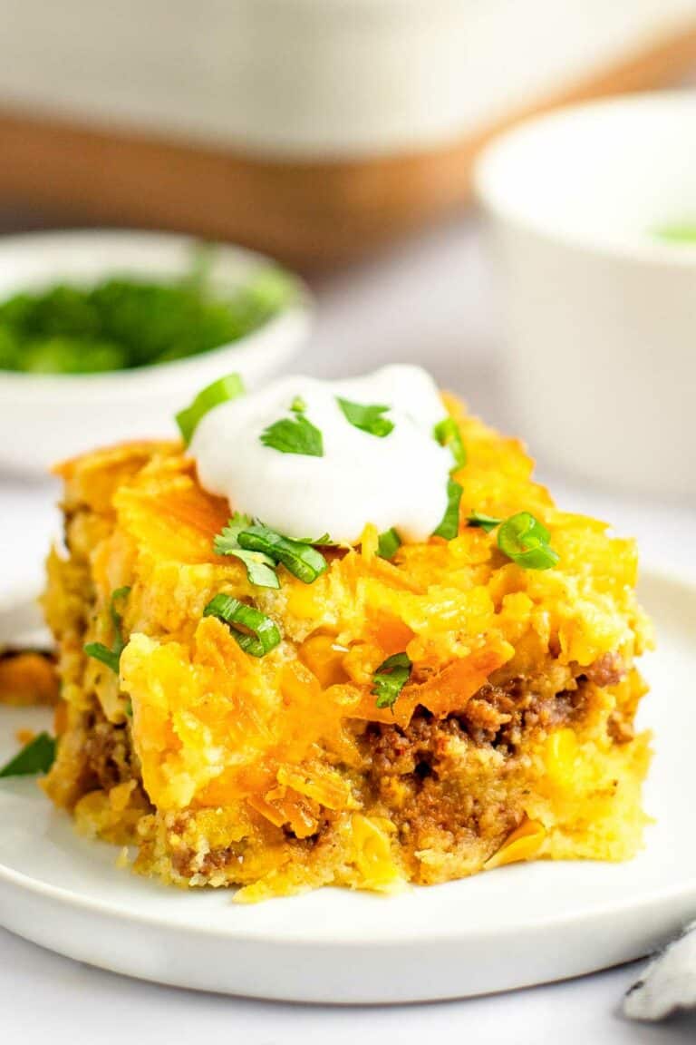 Mexican cornbread casserole topped with sour cream and fresh cilantro.