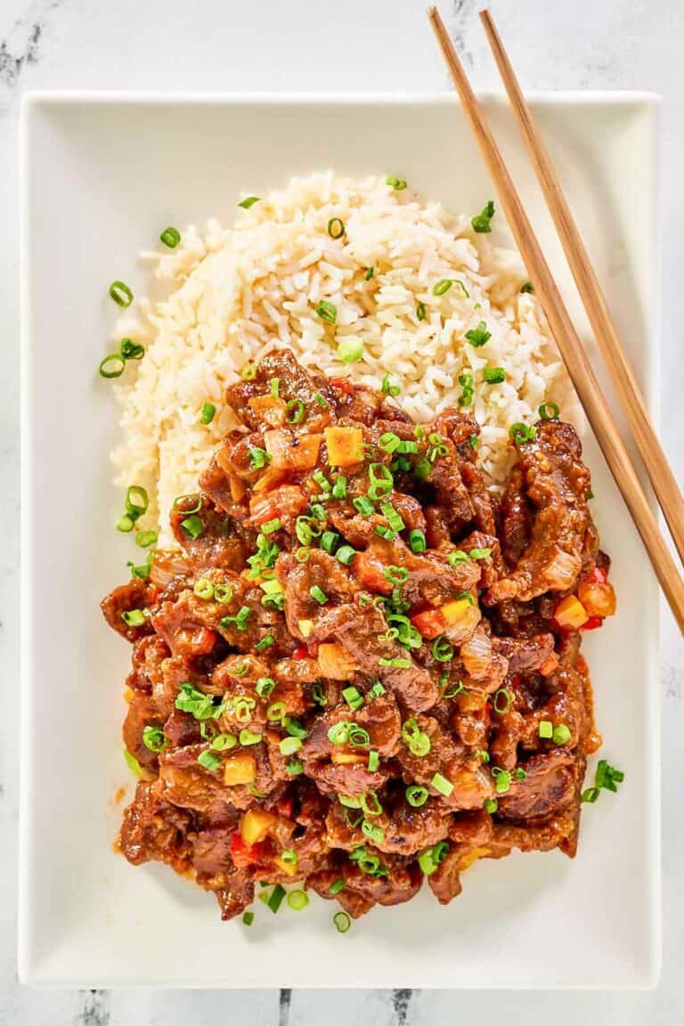 Copycat Panda Express Beijing Beef, rice, and chopsticks on a plate.