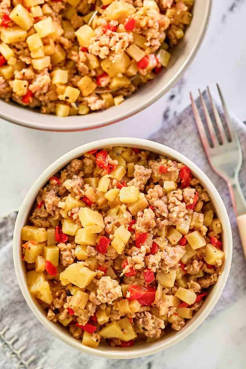 Sausage hash in two bowls and a fork next to them.