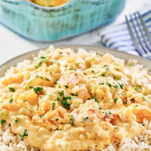 Shrimp and crab au gratin over rice on a plate.