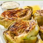 Grilled artichoke halves and a small cup of garlic aioli.