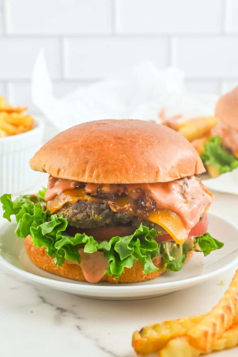 Copycat In-N-Out animal style burger on a plate and fries beside it.