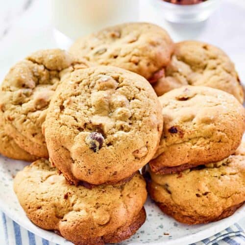 Copycat Panera kitchen sink cookies on a plate and a glass of milk behind it.