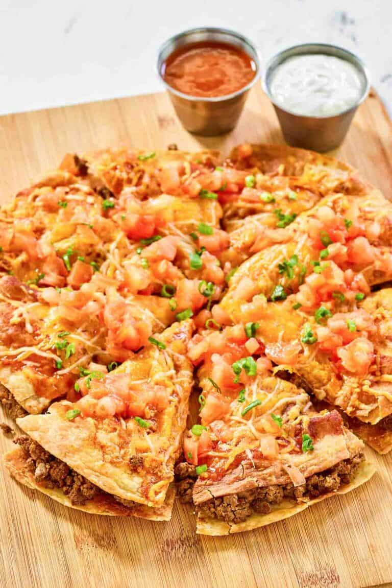 Copycat Taco Bell Mexican pizza and cups of taco sauce and sour cream.