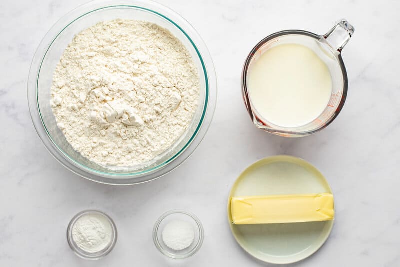 Homemade freezer biscuits ingredients on a marble surface.