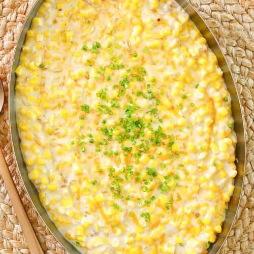 Cheesy creamed corn in a large copper skillet.