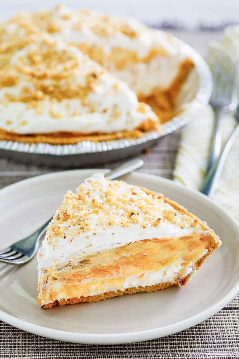Double layer pumpkin pie and a slice on a plate in front of it.