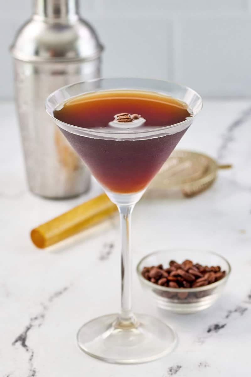 Copycat chili's espresso martini and a small bowl of espresso coffee beans.