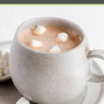 A mug of homemade hot chocolate and mini marshmallows on a plate.