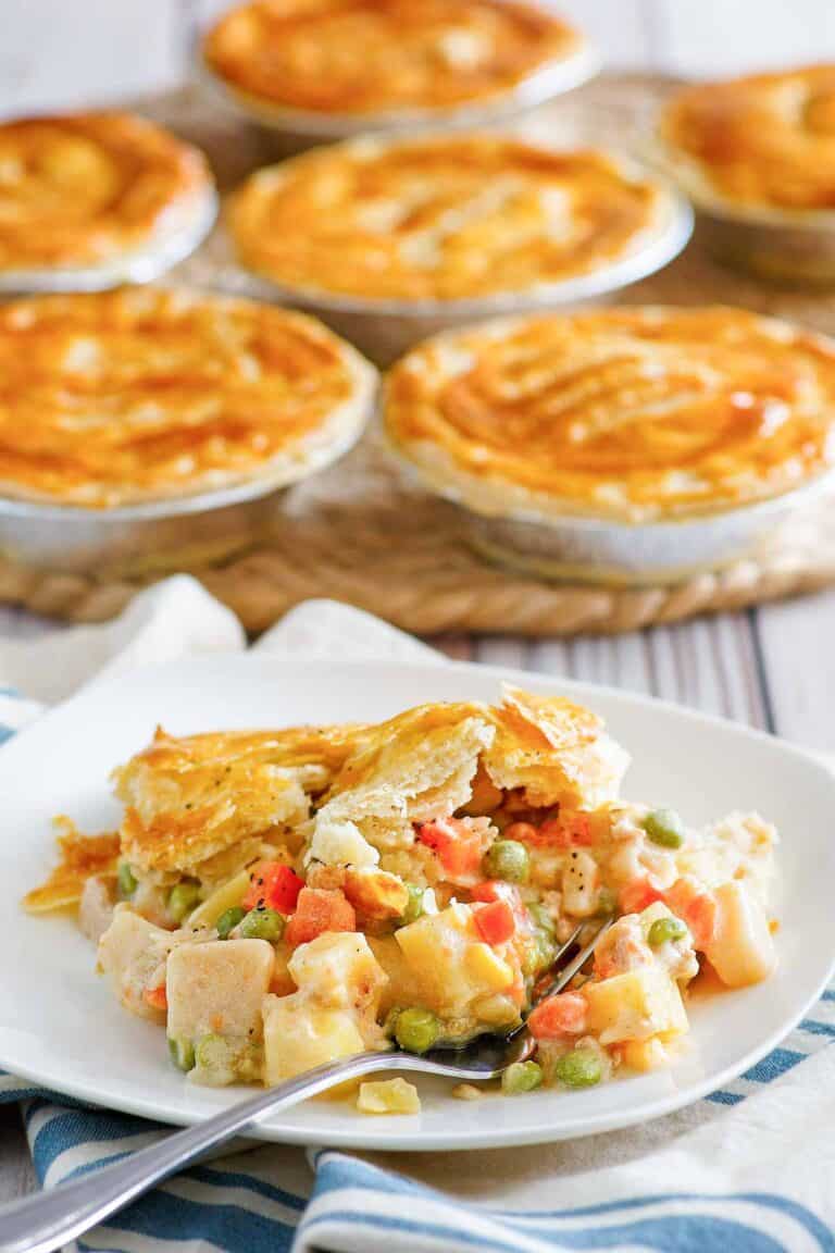 Copycat KFC chicken pot pie on a plate and more pies behind it.