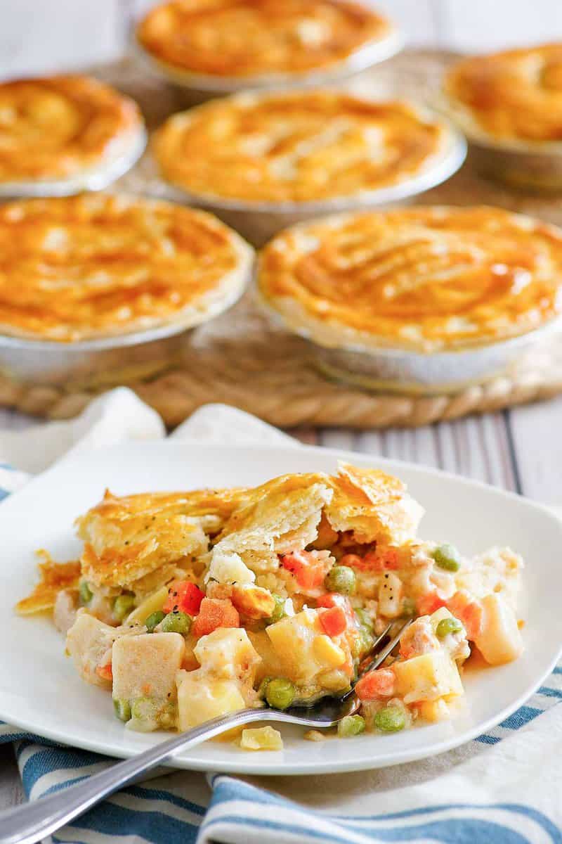 Copycat KFC chicken pot pie on a plate and more pies behind it.