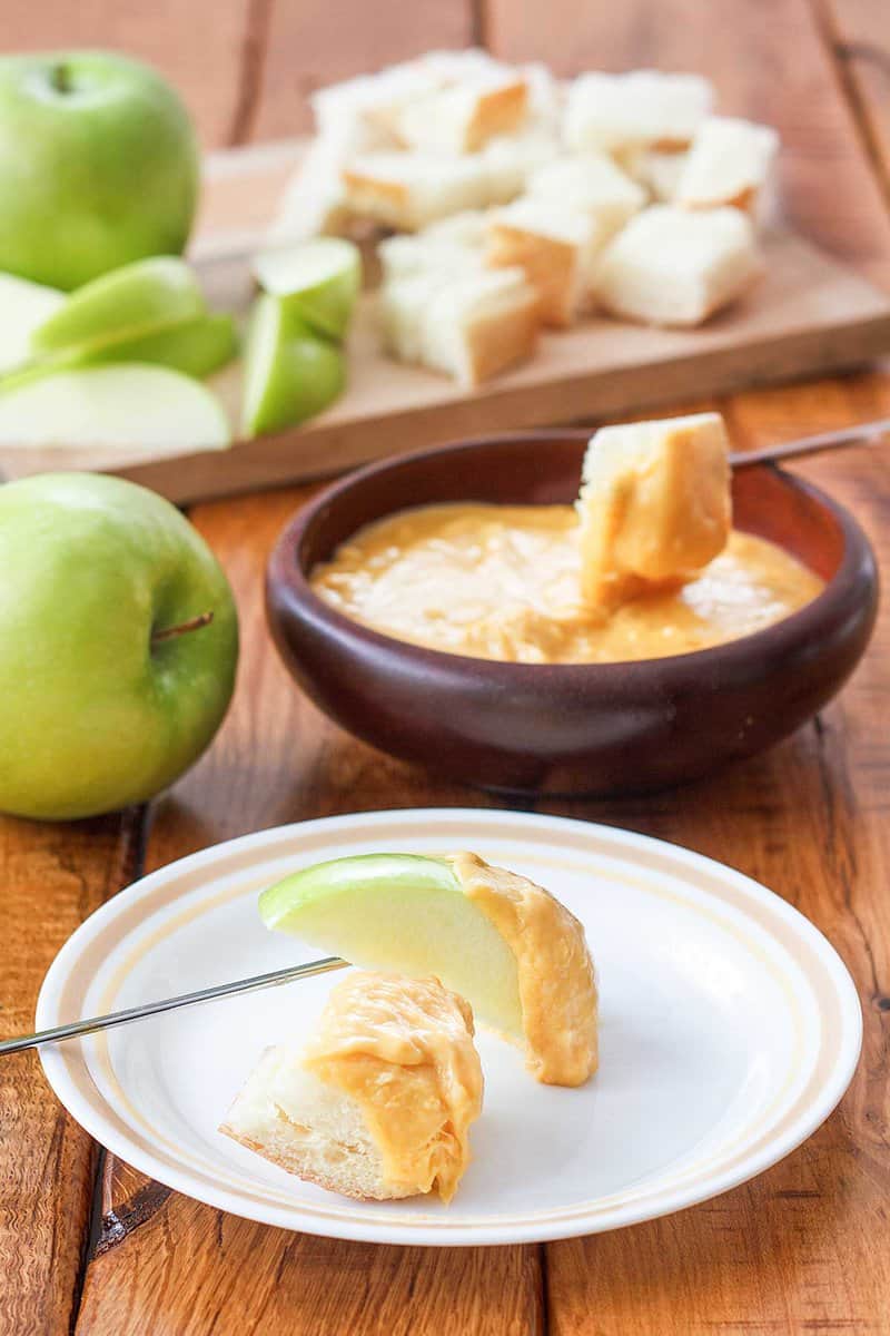 Copycat Melting Pot cheddar cheese fondue with sliced apples and bread cubes.