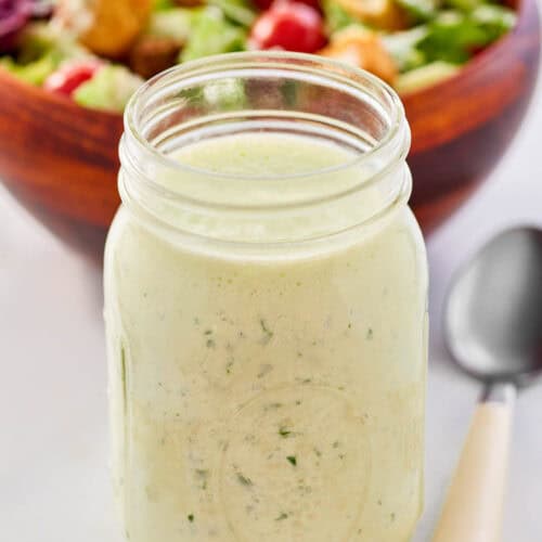 Homemade buttermilk ranch dressing, a salad, and a spoon.