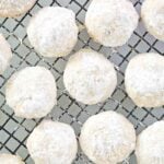Several homemade pecan sandies on a wire rack.