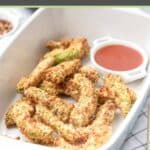 Air fryer avocado fries and a small cup of dipping sauce in a serving dish.