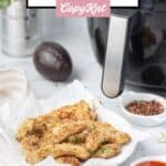 Crispy avocado fries on a plate and an air fryer behind it.