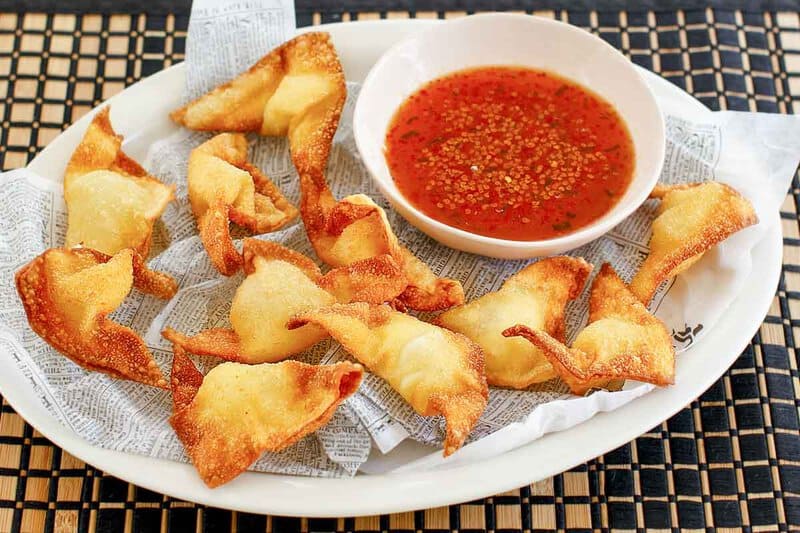 Cream cheese wontons with a small cup of dipping sauce.