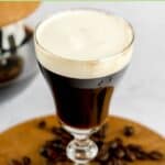 Traditional Irish coffee and coffee beans around it.