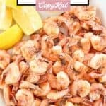 Freshly boiled shrimp and lemon wedges on a a platter.