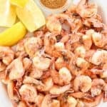 Lemon wedges and freshly boiled shrimp on a platter.