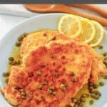 Homemade Buca de Beppo chicken limone garnished with capers on a plate.