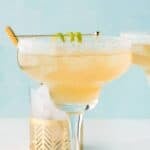 Copycat Chili's presidente margarita and a lime wedge on a coaster.