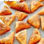 Homemade Mexican sopapillas scattered on parchment paper.