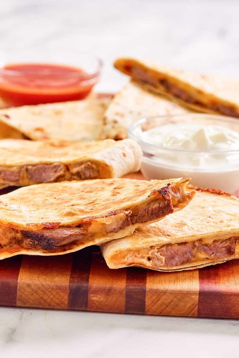 Copycat Taco Bell steak quesadilla on a wood serving board.