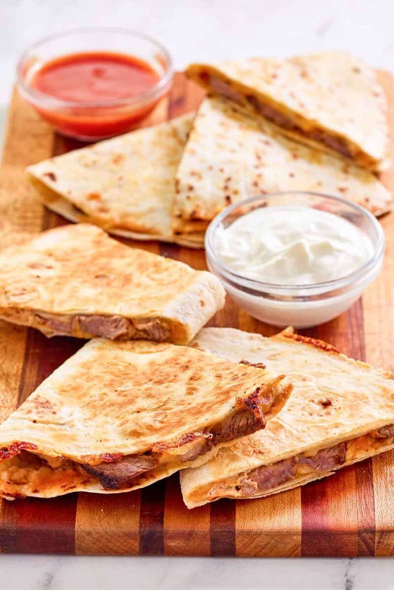 Copycat Taco Bell steak quesadilla, sour cream, and taco sauce.