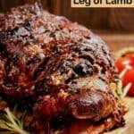 Oven roasted Indian style lamb leg on a wood board.